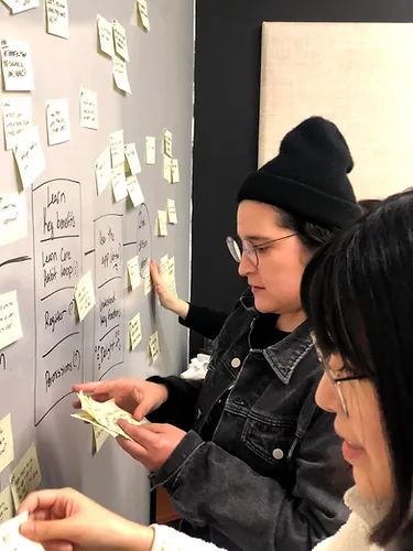 Sticky-note wall from the How Might We exercise